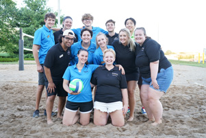 Dining & Culinary employees posing in the sand with a volleyball.