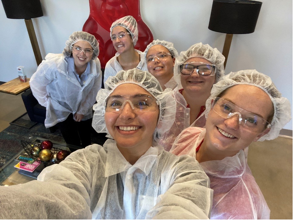 A group of interns wearing food safety equipment taking a selfie.
